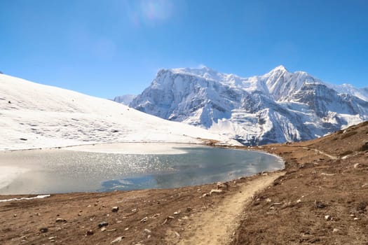 The Saano Khicho Lake in front Annapurna III, Gangapurna and Tarke Kang on a sunny day, next to the Ice Lake, Kicho Tal, Khicho Ice Lake, close to Manang, Annapurna Circuit Trek, Nepal 2022
