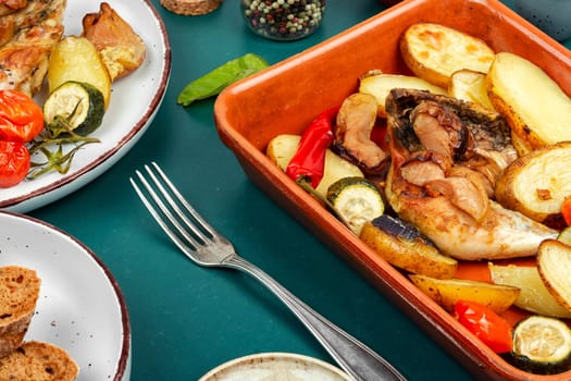 Spicy chicken meat baked with potatoes and apples. Homemade chicken legs baked in a baking dish