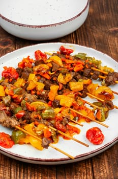 Lamb skewers with vegetables on a concrete kitchen table. Kebabs or lamb shish kebab. Flat lay.