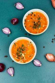 Fragrant onion soup in a ceramic bowl on a rustic wooden table.