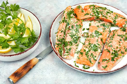 Fresh raw salmon fillet fish in garlic green marinade ready for baking.