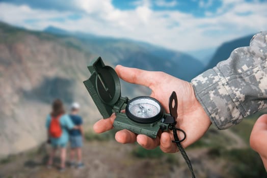 Man with compass in hand n Altai mountains. Travel concept.