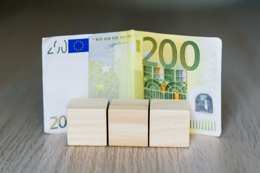 Wooden cubes blocks, money 200 Euro banknotes. Management big salary career conception