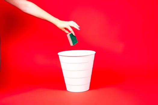 Washcloth in hand in front of the trash can, the concept of end of cleaning