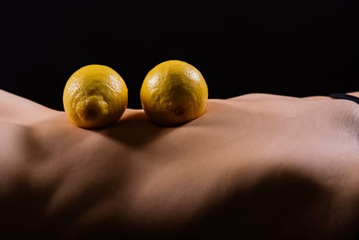 Lemon, natural vitamin c help skin whitening. Naked woman lying on back with fruit located
