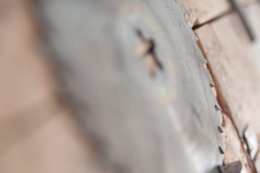 Circular saw blade on wood in a carpenter's workshop, with sharp teeth highlighted. Perfect for diy and home improvement projects, showcasing craftsmanship and precision in woodworking