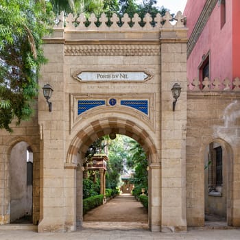 An ornate Mamluk-style archway leads to a tranquil garden at Prince Naguib Place, Cairo, Egypt, showcasing historic architecture