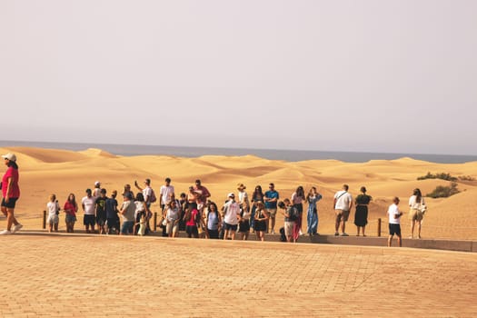 Gran Canaria, Spain, Canary Islands, Playa del Inglés - Jun 17, 2024. Tourist at a viewpoint of Dunes de Maspalomas. Maspalomas Dunes Nature Reserve.