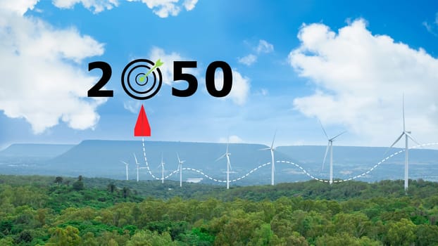 A red paper airplane flies around a wind turbine to generate electricity and flies to the letter 2050, Demonstrating the use of clean energy to reduce carbon dioxide to zero.