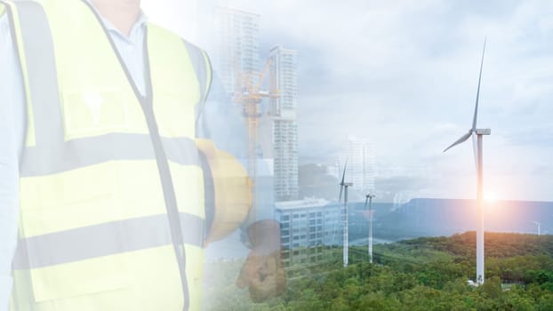 Double exposure picture of One Engineer working at windmill farm Generating electricity clean energy. Wind turbine farm generator by alternative green energy. Engineer checking control electric power.