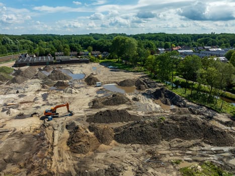 OLDENZAAL, NETHERLANDS - JULY 14, 2024: EAerial view on an excavator on an empty construction site