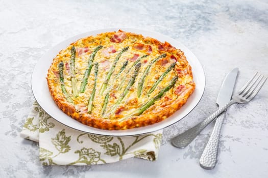 Homemade, freshly baked vegetable frittata  with green asparagus and bacon