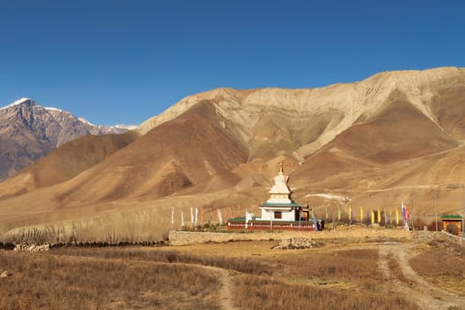 View onto Jangchup Choeten, a buddhist temple, pagoda, stupa in the dry landscape between Muktinath, Ranipauwa and Kagbeni, Annapurna Circuit Trek, Nepal 2022