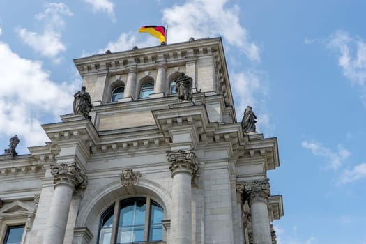 Detailed shot of the Berlin Reichstag against a blue sky with white clouds