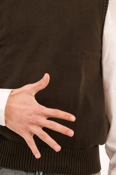 A male hand held in front of the stomach symbolizes the number 5 with the fingers.