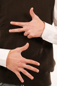 Two male hands held in front of the stomach symbolize the number 8 with the fingers.