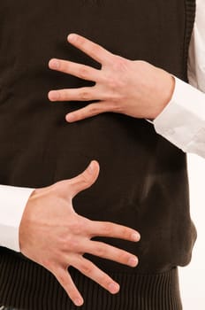 Two male hands held in front of the stomach symbolize the number 9 with the fingers.