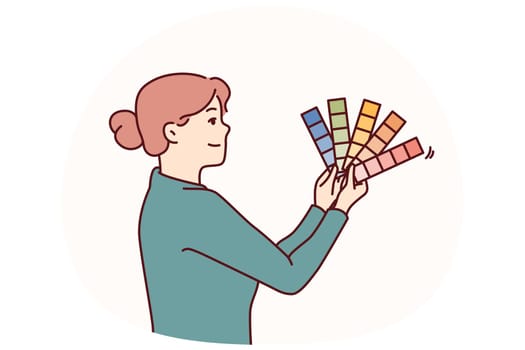 Woman is holding palette of colors and shades while considering decoration of new apartment or interior design. Businesswoman with palette decides on desired color scheme of own car