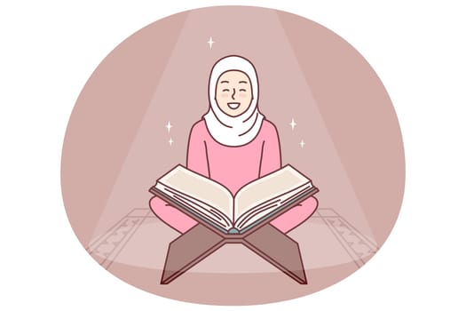 Muslim girl reads holy book quran turning to god allah sits in mosque or religious place for prayer. Positive woman in hijab studying arabic quran getting islamic traditional education
