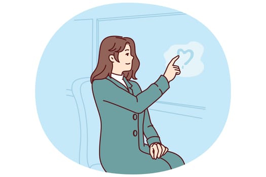 Woman passenger tram draws heart on glass, remembering beloved man and wishing to meet after separation. Girl in love depicts heart on steamy bus window, experiencing romantic feelings for boyfriend