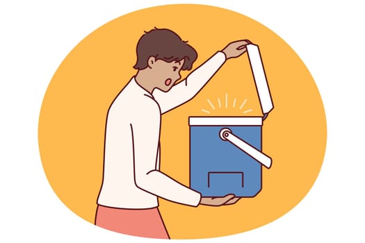 Surprised man opens portable refrigerator for ice cream or drink and is shocked to see contents. Young guy with portable refrigerator yells wow sees cool drinks for picnic or camping