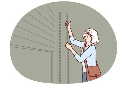 Elderly woman closes shop to store after end of working hours and departure of customers from store or cafe. Grey-haired female small business owner ends working day by closing doors to trading floor