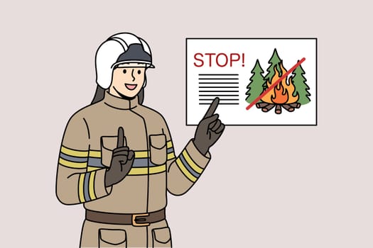 Man firefighter reminds of ban on lighting fires in forest, standing in work uniform and helmet. Professional firefighter smiles agitating not to start fires in parks while walking.
