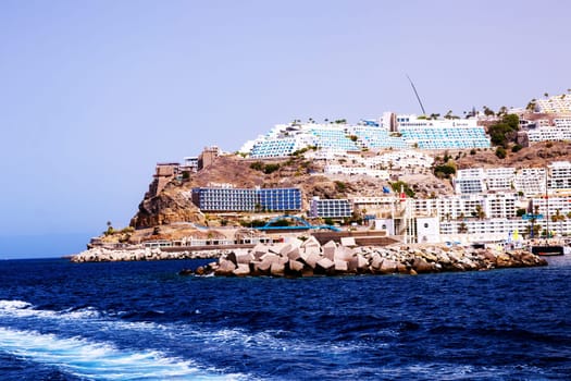 Gran Canaria, Spain, Canary Islands, Puerto Rico - Jul 17, 2024. View of the tourist village Puerto Rico from the sea. Entrance to the harbour.