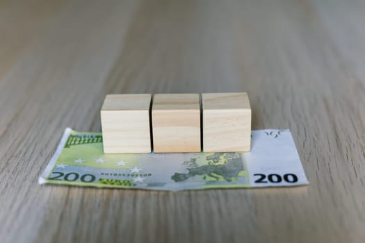 Wooden cubes blocks, money 200 Euro banknotes. Management big salary career conception