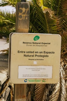 Gran Canaria, Spain, Canary Islands, Playa del Inglés - Jul 17, 2024 A sign at the entrance to the Maspalomas Dunes Nature Park, asking visitors to observe the protection regulations.
