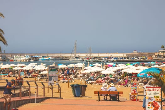 Gran Canaria, Spain, Canary Islands, Puerto Rico - Jul 18, 2024. The Playa de Porto Rico beach with a lot of tourists.