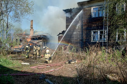 extinguishing the fire of a wooden house. High quality photo