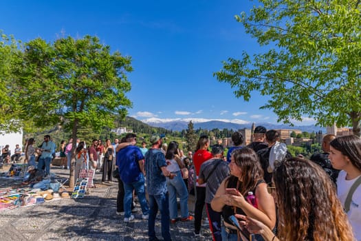 Granada, Spain: April 15, 2024: People at the Alhambra palace with the Sierra Nevada in the background, Granada, Andalusia, Spain