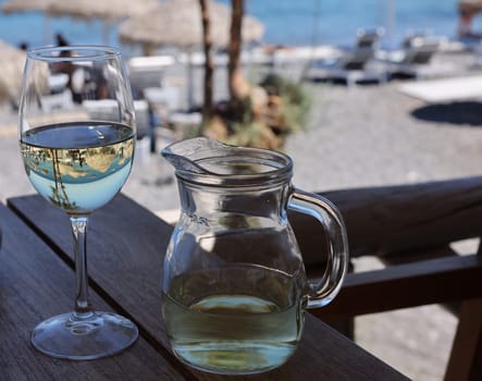 A glass of white wine at a restaurant by the beach in Kamari, Santorini. Greece
