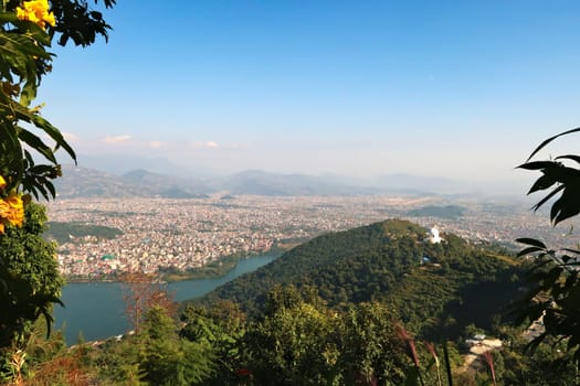 View onto the World Peace Pagoda in front ot the town of Pokhara at the shore of Phewa Lake, on the way up to the shiva statue at the Pumdikot Religious Area, Nepal 2022