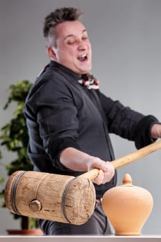 Fanatical salesman swinging a sledgehammer to destroy a piggy bank, representing his greed and willingness to do anything for money