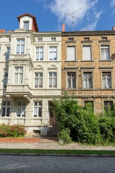 A renovated and a dilapidated terraced house with several floors and a front garden
