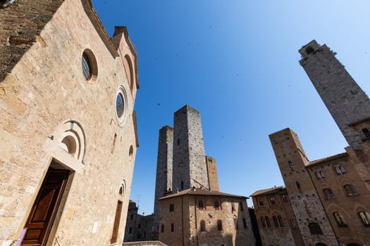 San Gimignano, Italy - 29 June 2023: Italy travel destionation, medieval tower skyscraper, blue sky