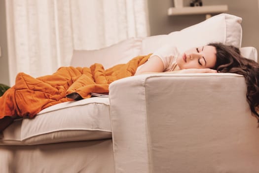 Lifestyle A young woman is enjoying a peaceful moment at home, taking a nap on her comfortable couch
