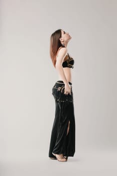 Dancer is gracefully posing while performing a belly dance, showcasing the beauty and elegance of this traditional dance form