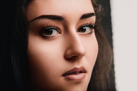Portrait of a young woman with brown eyes and dark hair, her expression is neutral but suggests deep thought and reflection