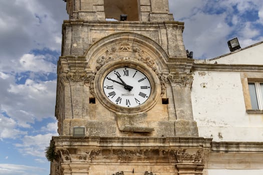 Martina Franca, Italy, Apulia - May 25, 2024: Civic Tower (Torre dell'Orologio) next to University Palace, located in Plebiscito Square (Piazza Plebiscito)