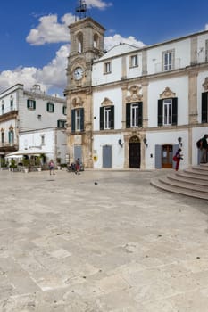 Martina Franca, Italy, Puglia - May 25, 2024: Plebiscito Square (Piazza Plebiscito) with Civic Tower (Torre dell'Orologio) and University Palace