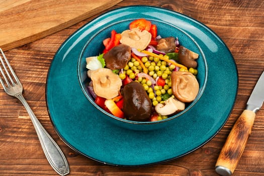 Healthy vegan salad with marinated mushrooms, green peas and pepper. Copy space.