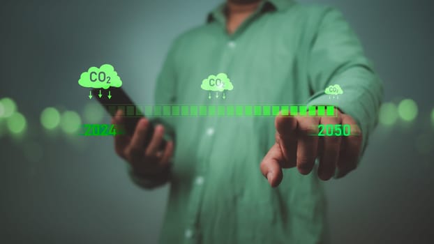 Carbon reduction and carbon credit to limit global warming from climate change, Businessman points to CO2 reduction symbol by 2050, Bio Circular Green Economy concept, Greenhouse gas, Net zero.