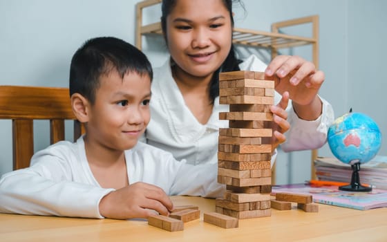 Asian family spending time together on holiday on study desk at home, Mother play wood block toy with son in house, Activity relationship, Brain and concentration training games.