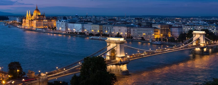 The evening skyline of Budapest, Hungary. View over the city including the landmarks of the Hungarian Parliament Building, the Szechenyi Chain Bridge and St Stephens Basilica.