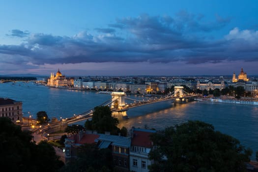 The evening skyline of Budapest, Hungary. View over the city including the landmarks of the Hungarian Parliament Building, the Szechenyi Chain Bridge and St Stephens Basilica.