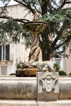 Martina Franca, Italy, Puglia - May 20, 2024: Fountain with dolphins located at Piazza Rome in front of Palazzo Ducale next to St. Stephen's Gate (Porta di Santo Stefano)