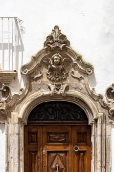 Ornate portal above the door of a tenement house, a typical sight in narrow streets in Mediterranean countries, Martina Franca, Italy, Apulia
